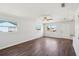 Spacious living room with wood flooring, a ceiling fan, white walls, and natural light from well-placed windows at 2318 Vincent Rd, Orlando, FL 32817