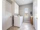 Practical laundry room equipped with washer, dryer, cabinets, and a window providing natural light at 2361 Baker Ave, Orlando, FL 32833