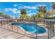 Sparkling in-ground pool surrounded by a safety fence and lush tropical landscaping at 2361 Baker Ave, Orlando, FL 32833