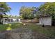 Fenced backyard featuring a fire pit, green grass and a shed at 241 S Marydell Ave, Deland, FL 32720