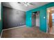 Cozy bedroom with teal and gray walls, neutral carpeting, and an open closet with hanging rack at 241 S Marydell Ave, Deland, FL 32720