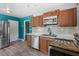 Kitchen featuring stainless steel appliances, wood cabinets, backsplash and adjacent dining area at 241 S Marydell Ave, Deland, FL 32720