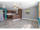 Open kitchen and dining area featuring stainless steel appliances, and grey wood grain flooring at 241 S Marydell Ave, Deland, FL 32720