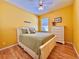 Bright bedroom with a white bed frame, yellow walls and light hardwood floors at 2519 Cypress Trace Cir, Orlando, FL 32825