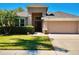 Inviting single-Gathering home featuring a well-manicured lawn, mature landscaping, and an attached two-car garage at 2519 Cypress Trace Cir, Orlando, FL 32825