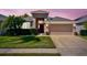 Inviting single-Gathering home featuring a well-manicured lawn, mature landscaping, and an attached two-car garage at 2519 Cypress Trace Cir, Orlando, FL 32825