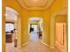 Open hallway featuring tile flooring and arched doorways to the kitchen, living room, and bedroom at 2519 Cypress Trace Cir, Orlando, FL 32825