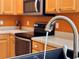 Close up of a modern kitchen faucet and sink with stainless steel appliances in the background at 2519 Cypress Trace Cir, Orlando, FL 32825