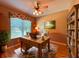 Well-lit home office features a rustic wooden desk, ceiling fan, and built-in wooden bookshelf at 2519 Cypress Trace Cir, Orlando, FL 32825