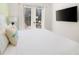 Bright bedroom featuring white bedding, TV, and balcony access at 2967 Latitude Ln, Kissimmee, FL 34747