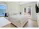 Bright bedroom featuring a king bed, soft green accent wall, and french doors leading to the outside at 2967 Latitude Ln, Kissimmee, FL 34747