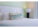 Comfortable bedroom featuring a plush white bed, a decorative pillow and a bedside table lamp at 2967 Latitude Ln, Kissimmee, FL 34747