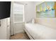 Bright bedroom with white walls, daybed, and beach-themed art creates a serene coastal retreat at 2967 Latitude Ln, Kissimmee, FL 34747