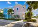 Eye-catching two-story pink home with detailed trim and lush tropical landscaping at 2967 Latitude Ln, Kissimmee, FL 34747