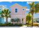 Attractive pink two-story home with a balcony and lush tropical landscaping at 2967 Latitude Ln, Kissimmee, FL 34747