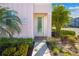 Charming home exterior with a light pink façade, lush landscaping, and inviting front door at 2967 Latitude Ln, Kissimmee, FL 34747