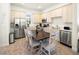 Well-lit kitchen featuring stainless steel appliances, neutral countertops, and a dark wood dining table at 2967 Latitude Ln, Kissimmee, FL 34747