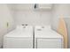 Efficient laundry room with modern Samsung washer and dryer, ironing board, and storage shelf at 2967 Latitude Ln, Kissimmee, FL 34747