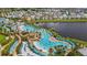 Picturesque aerial view of the community featuring a large pool area, lake, colorful houses, and landscaped grounds at 3083 Pirate Way, Kissimmee, FL 34747
