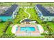 Aerial view of colorful townhomes in a community with manicured lawns, sidewalks, palm trees, and a pool at 3083 Pirate Way, Kissimmee, FL 34747