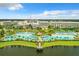 Aerial view of a lakefront resort with multiple pools, palm trees, thatched-roof huts, and sun loungers at 3083 Pirate Way, Kissimmee, FL 34747