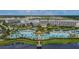 Expansive aerial view of a resort featuring multiple pools, a lakeside pier, cabanas, and meticulously landscaped grounds at 3083 Pirate Way, Kissimmee, FL 34747