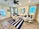 Bright living room featuring a large sectional sofa, striped rug, and coastal-themed decor at 3083 Pirate Way, Kissimmee, FL 34747
