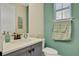Stylish powder room with modern fixtures, decorative mirror, and serene wall color at 3083 Pirate Way, Kissimmee, FL 34747