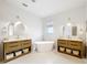 Bright bathroom featuring dual vanities, a freestanding tub, and modern fixtures at 319 Arbor Pointe Ave, Minneola, FL 34715