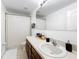 Bathroom with a single sink vanity, large mirror, dark wood cabinets, and neutral tile floor at 319 Arbor Pointe Ave, Minneola, FL 34715