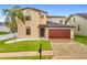 Two-story home with a well-maintained lawn and a two-car garage at 319 Arbor Pointe Ave, Minneola, FL 34715