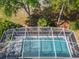 Aerial view looking down at a beautiful screened pool, with patio and landscaped surroundings at 358 Morning Creek Cir, Apopka, FL 32712