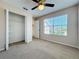 A carpeted bedroom with a closet, window with blinds, and a ceiling fan at 358 Morning Creek Cir, Apopka, FL 32712