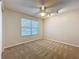 A carpeted bedroom featuring a ceiling fan and a window with blinds at 358 Morning Creek Cir, Apopka, FL 32712