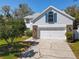 Exterior of a two-story home showcasing a two-car garage and a well-kept lawn at 358 Morning Creek Cir, Apopka, FL 32712