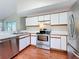Bright kitchen features stainless steel appliances, white cabinets, and wood-look floors at 358 Morning Creek Cir, Apopka, FL 32712