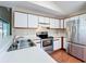 Bright kitchen features stainless steel appliances, white cabinets, and wood-look floors at 358 Morning Creek Cir, Apopka, FL 32712