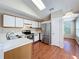 Bright kitchen features stainless steel appliances, white cabinets, and wood-look floors at 358 Morning Creek Cir, Apopka, FL 32712