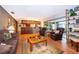 Cozy living room with wood paneling, wood floors, and a bar with glass display shelving at 381 Maple Ct, Oviedo, FL 32765