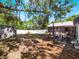 Large, shaded backyard with mature trees, storage shed, outdoor seating, and a white picket fence at 392 W Minnehaha Ave, Clermont, FL 34711