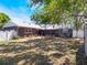Large fenced backyard featuring a brick patio, mature trees, and a storage shed at 392 W Minnehaha Ave, Clermont, FL 34711