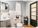 Charming bathroom with white-tiled walls, a pedestal sink, and a dark-trimmed door at 392 W Minnehaha Ave, Clermont, FL 34711