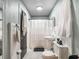 Bright bathroom with white tiling, a pedestal sink, and contrasting dark door frame and fixtures at 392 W Minnehaha Ave, Clermont, FL 34711