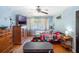 Well-lit bedroom with hardwood floors, a mounted TV, and a cozy bed with a colorful quilt at 392 W Minnehaha Ave, Clermont, FL 34711
