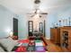 Bright bedroom featuring light blue walls, hardwood floors, and a colorful custom patchwork quilt on the bed at 392 W Minnehaha Ave, Clermont, FL 34711