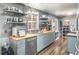 Open kitchen with stainless steel appliances, shaker cabinets, butcher block countertops, open shelving, and wood flooring at 392 W Minnehaha Ave, Clermont, FL 34711