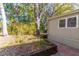 Exterior of home featuring a wood-lined flower bed and patio with mature trees at 410 N Niblick Ln, Lake Mary, FL 32746