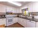 Bright kitchen featuring white cabinetry, granite countertops, and a colorful mosaic backsplash at 410 N Niblick Ln, Lake Mary, FL 32746