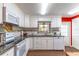 Bright kitchen featuring white cabinetry, granite countertops, and a colorful mosaic backsplash at 410 N Niblick Ln, Lake Mary, FL 32746