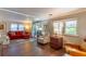 Comfortable living room featuring wood floors, a cozy couch, and ample natural light at 410 N Niblick Ln, Lake Mary, FL 32746